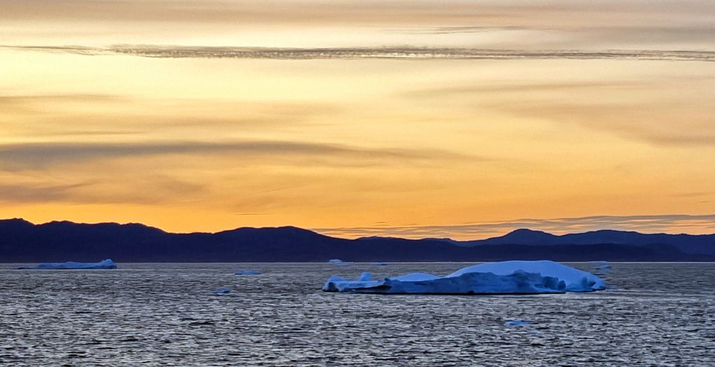 Sonnenaufgang mit Eisberge in Grönland von der HANSEATIC inspiration aus gesehen