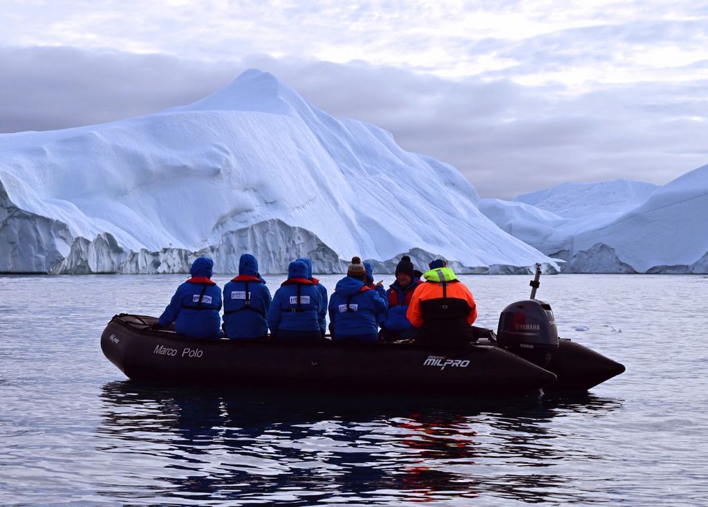 Passagiere im Ilulissat-Icefjord, die auf Eisberge starren