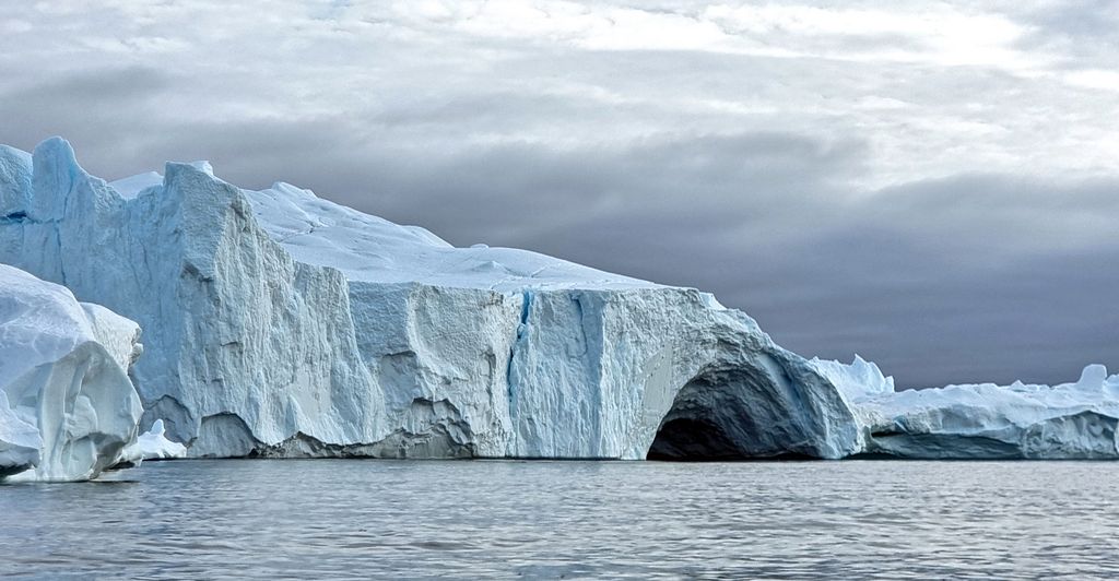 Ein Eisberg mit Höhle im Eisfjord von Ilulissat
